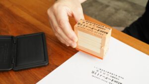 法人向けのゴム印が並び、書類に押されているビジネスシーンの写真