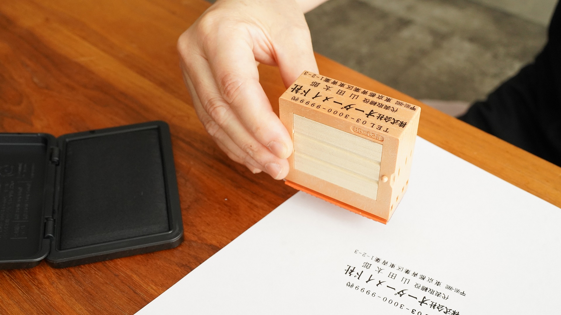法人向けのゴム印が並び、書類に押されているビジネスシーンの写真
