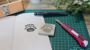 消しゴムはんこを彫っている作業中の机と必要な道具が並ぶ様子。