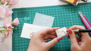 消しゴムはんこや道具が並ぶスタンプ作りの作業風景を写した画像。