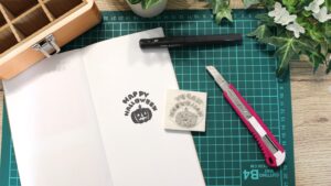 ハンドメイド作品を前に、販売に悩む女性作家が机に向かっている様子