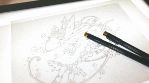 ペンと紙に描かれたイラストの図案