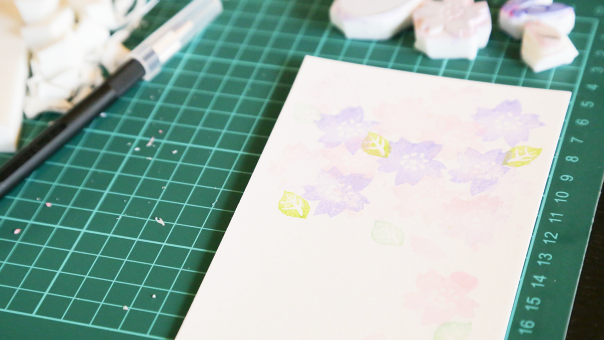 机の上に並べられた消しゴムはんこ制作道具と完成スタンプ作品
