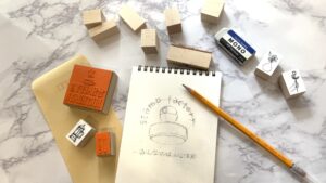 手描きのイラストノートが並び、スタンプアイデアを探している様子。