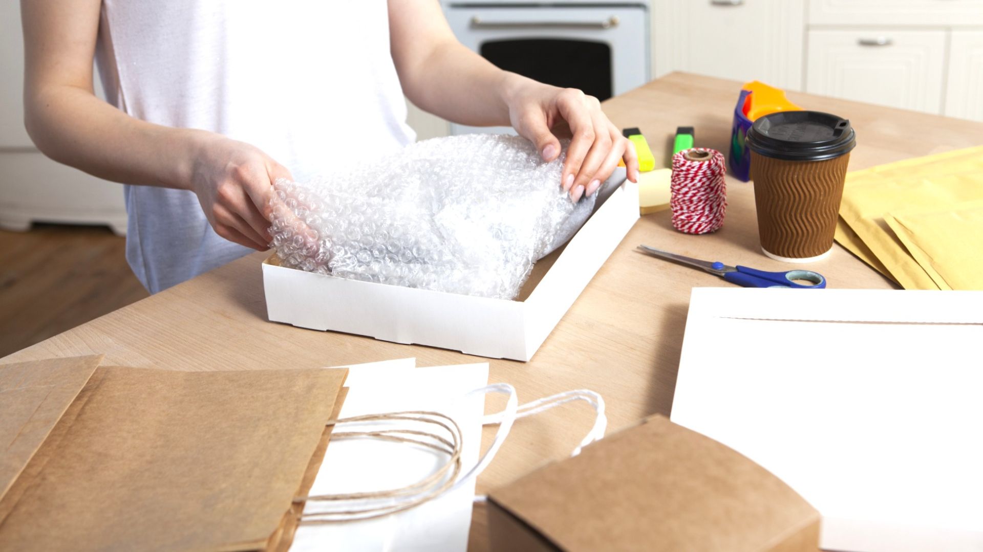 ラッピングされたラバースタンプと梱包資材が並ぶ、手作り感のある作業デスクの写真。