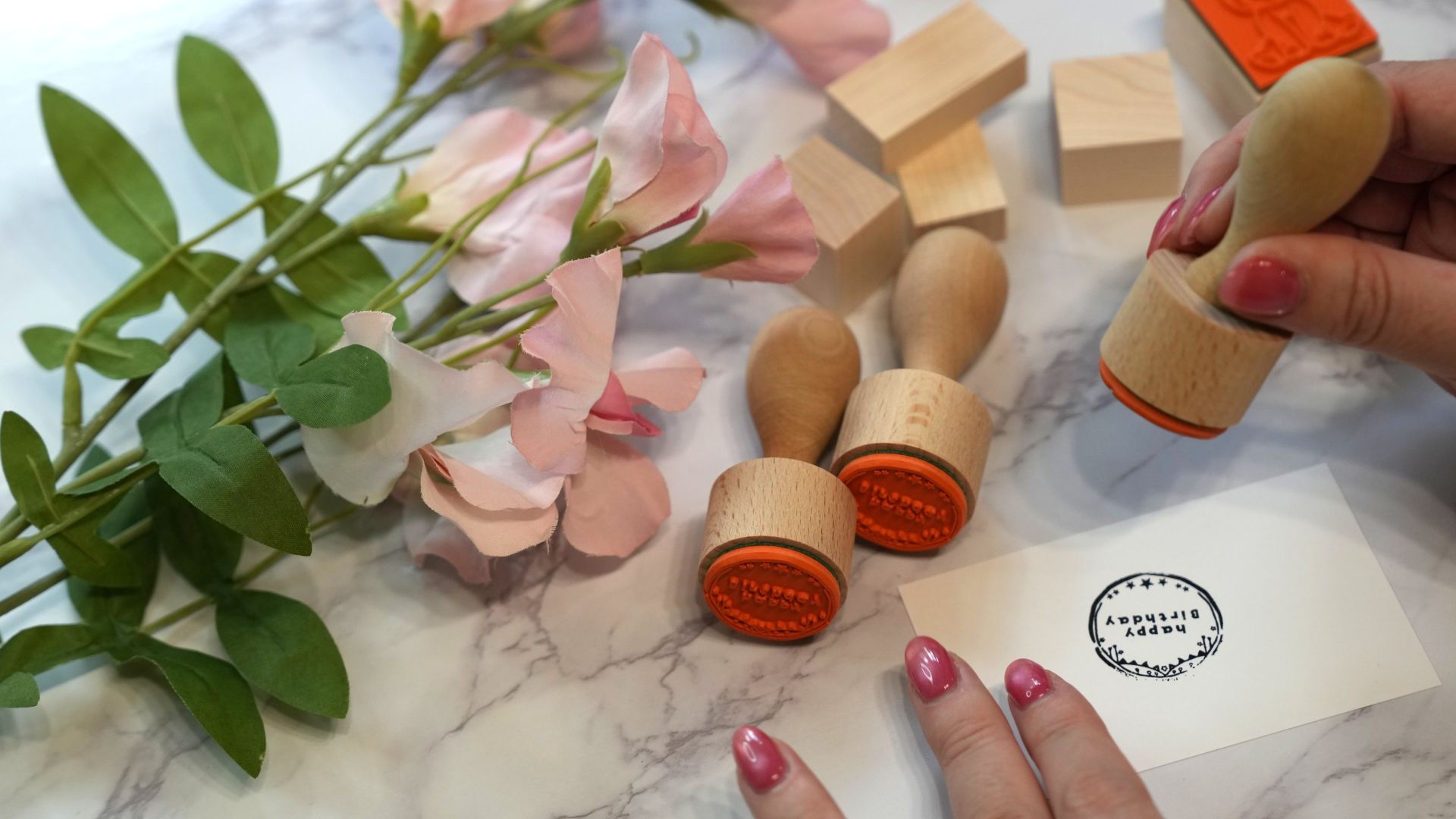 木製のオリジナルスタンプが並んだハンドメイド作業風景を撮影した写真。