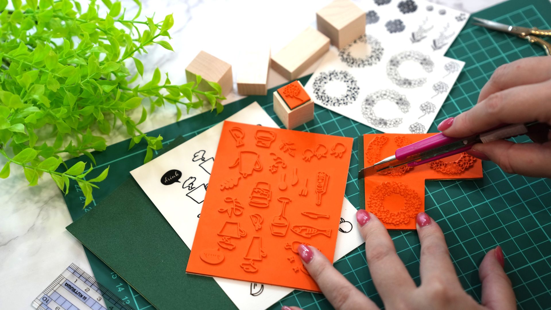 テーブルの上でスタンプを作成するハンドメイド作家の手元と道具の様子。