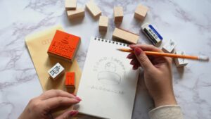 木製のオリジナルスタンプを机に並べ、デザインスケッチとともに撮影した画像。