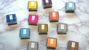 色とりどりのインクパッドが並ぶデスクの写真。