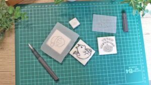手作りのオリジナルスタンプが並び、癒しを感じる温かな作業風景。