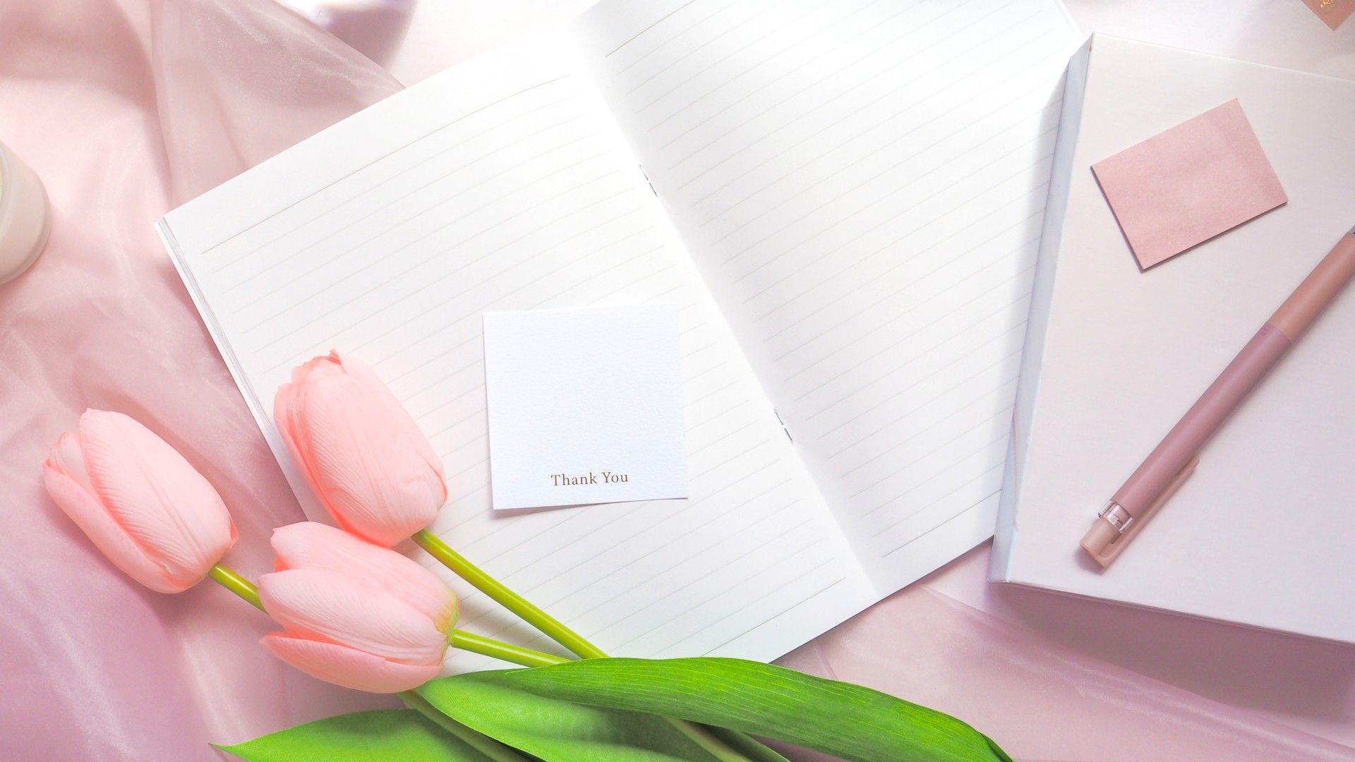 かわいいフォントが押印された印影のメッセージカードと手帳や文具が一緒に撮影された明るい雰囲気の写真。