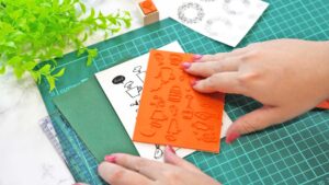 オリジナルスタンプのデザイン案と完成品を机に並べ、作成工程が分かるイメージ写真。