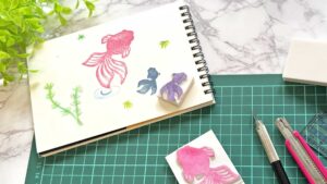 消しゴムはんこと彫刻刀、完成したスタンプが並ぶ初心者向け制作風景