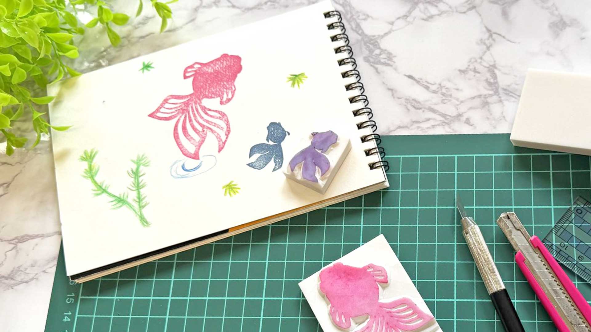 消しゴムはんこと彫刻刀、完成したスタンプが並ぶ初心者向け制作風景