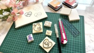 やさしいイラストのオリジナルスタンプと文房具が並ぶ、癒しを感じる作業風景