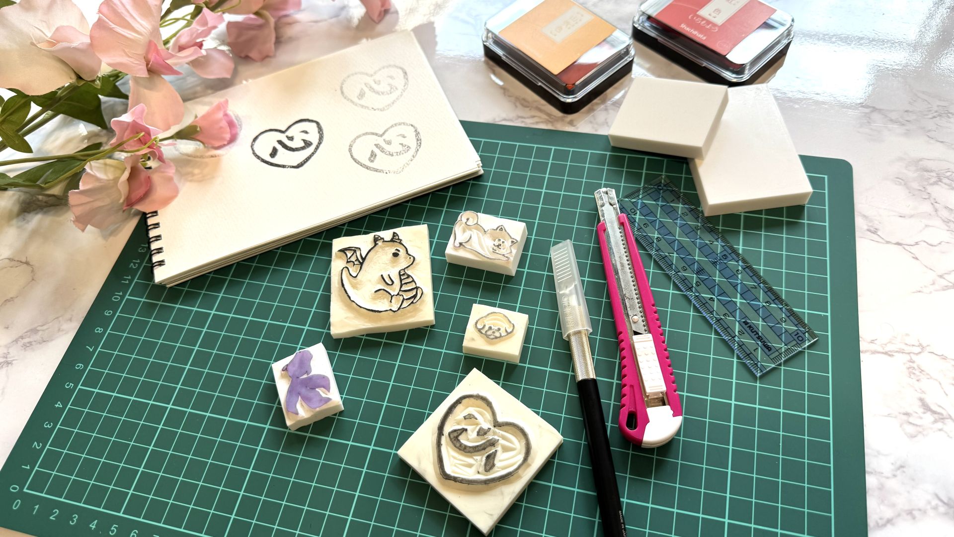 やさしいイラストのオリジナルスタンプと文房具が並ぶ、癒しを感じる作業風景