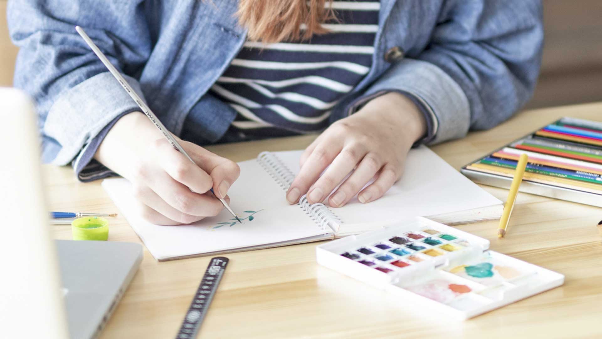 イラストアイデアを考えるためのお題ルーレットと、スケッチブックやペンが並んだイメージ。