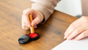 木製のはんこと朱肉が並べられた写真。はんこと印鑑の基本をイメージできる落ち着いたビジュアル。