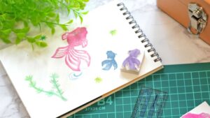 彫刻刀で彫った消しゴムはんこをカラフルなインクでスタンプを押している工作の様子
