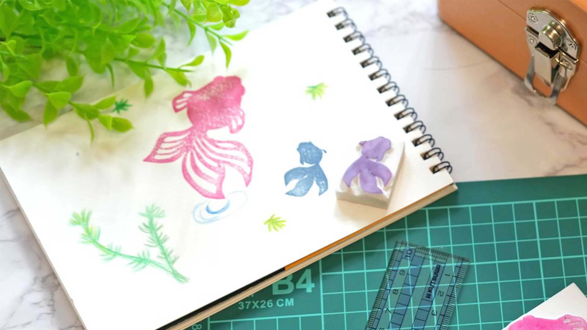 彫刻刀で彫った消しゴムはんこをカラフルなインクでスタンプを押している工作の様子