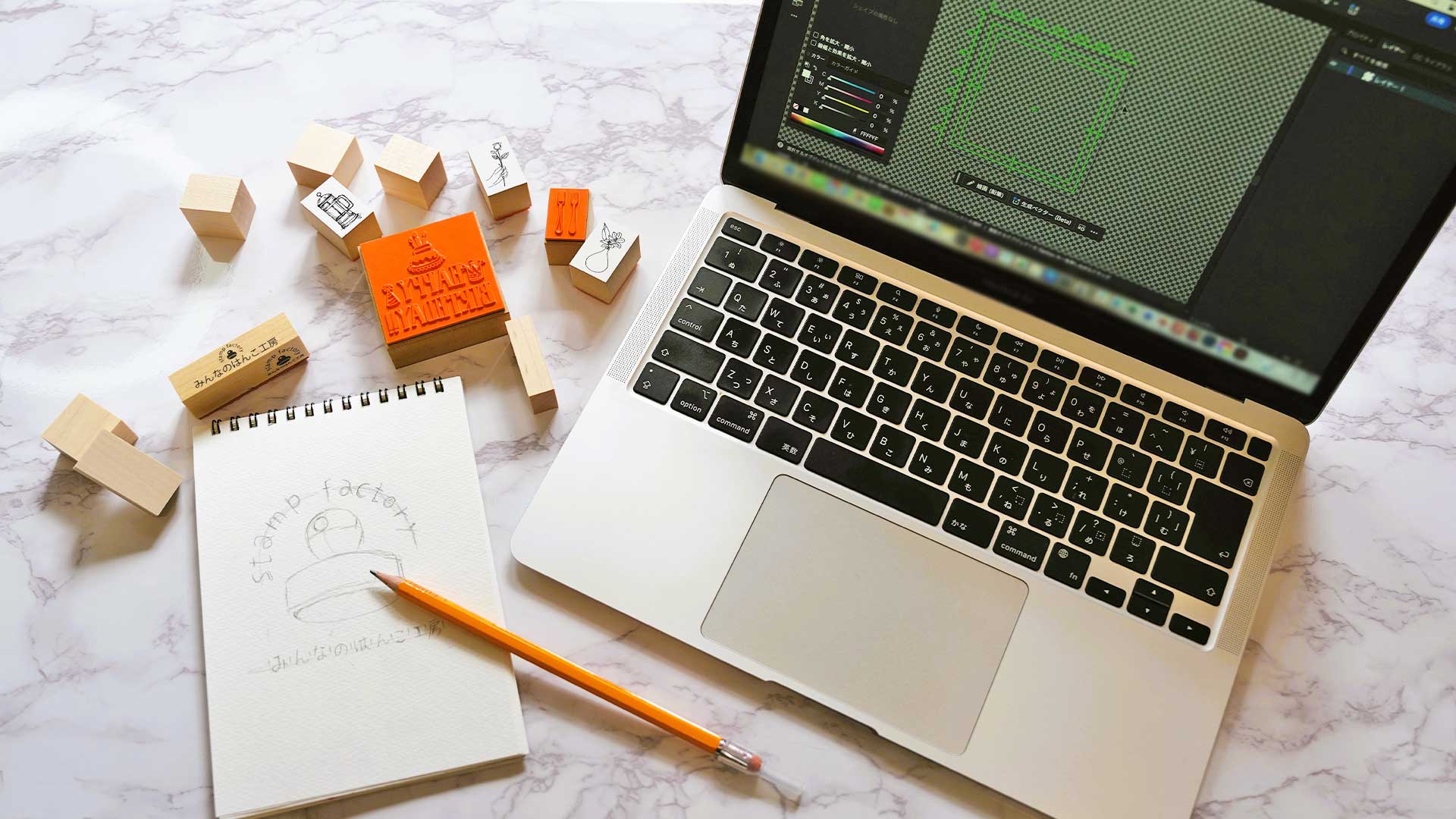 イラスト原稿と完成したオリジナルスタンプが並び制作工程をイメージできる写真