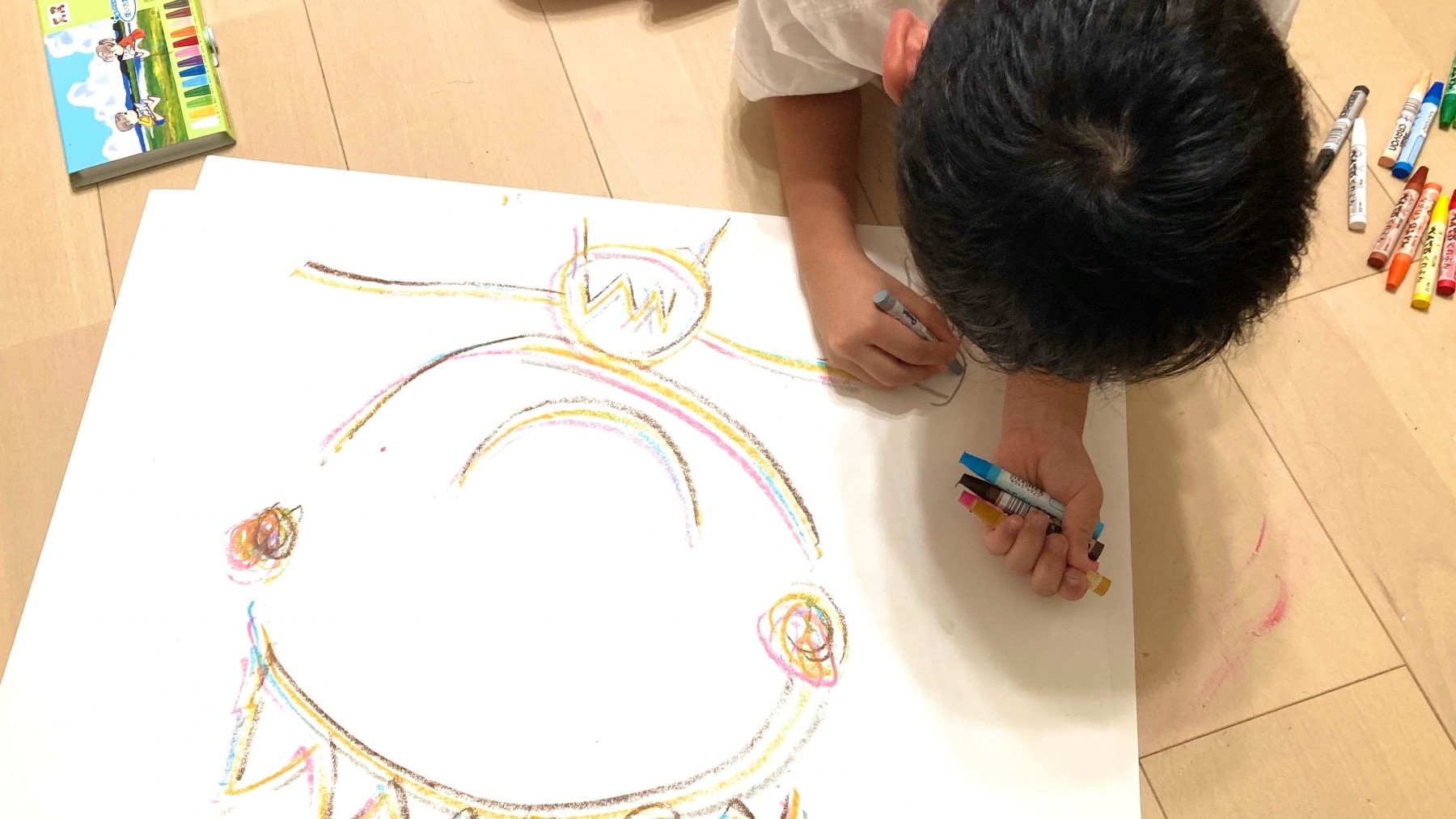 子どもがスタンプの絵柄を書いて楽しげに作業している様子。