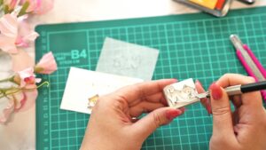 100均の道具を使って消しゴムはんこを制作している様子と、完成したハンドメイドはんこを並べたクラフト作業風景を表現した画像。