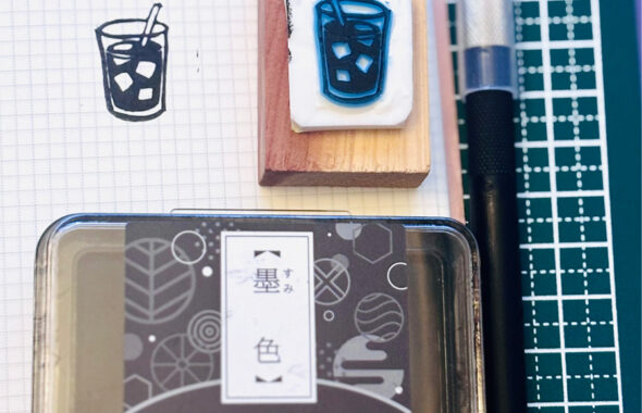 手作りの消しゴムはんことスタンプ台が作業台に置いてあるイメージ