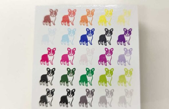 MDFの白箔素材の背見出しに様々な色で印刷をしている様子